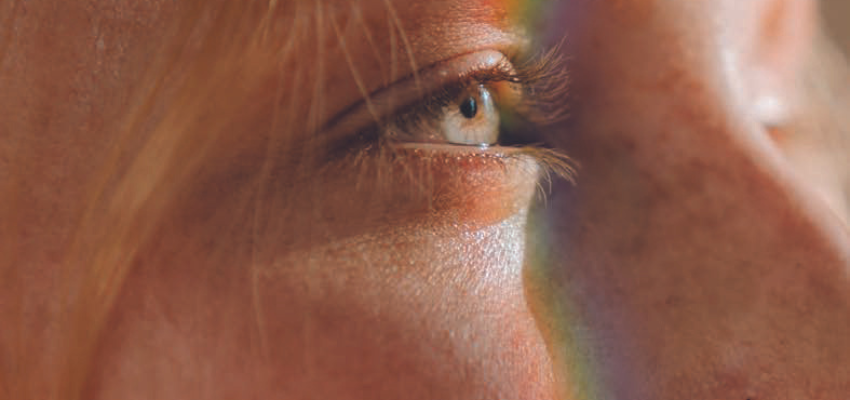 girl looking out with a rainbow stripe on her face