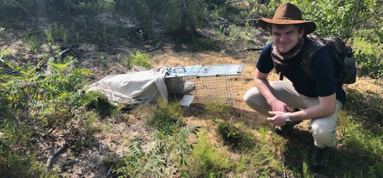 Cade Smelley in the field after setting a live trap over a Gopher Tortoise burrow. 