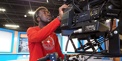 Student filming a news program.