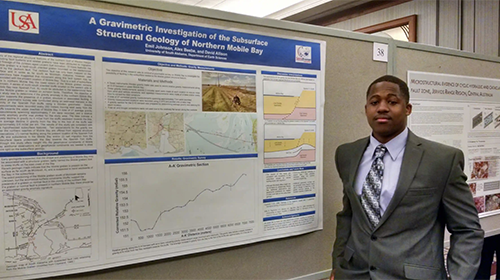 Male student standing in front of his Geology project.