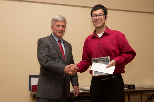 Cameron Young accepts the Outstanding Contribution Award from Dr. Bill Williams.