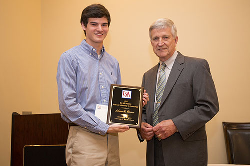 Adam Olivier receives an Endowment Scholarship from Dr. Bill Williams.