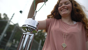 Student working with wind chime outside.