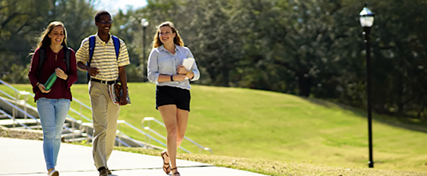 Three students walking across campus.