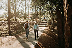 Two students walking towards Humanities building on campus.
