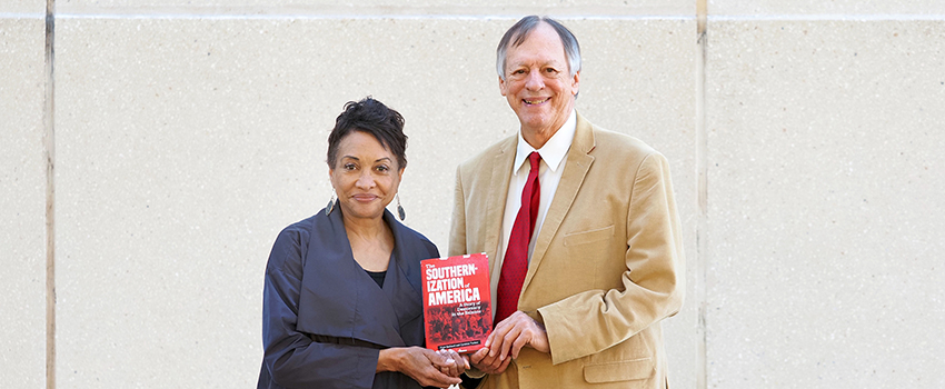 Gaillard and Tucker holding the book they published together.
