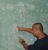 Man working equations on chalkboard