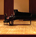 Student playing the piano on stage