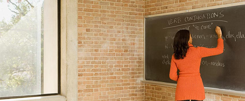 Female writing on a chalk board.