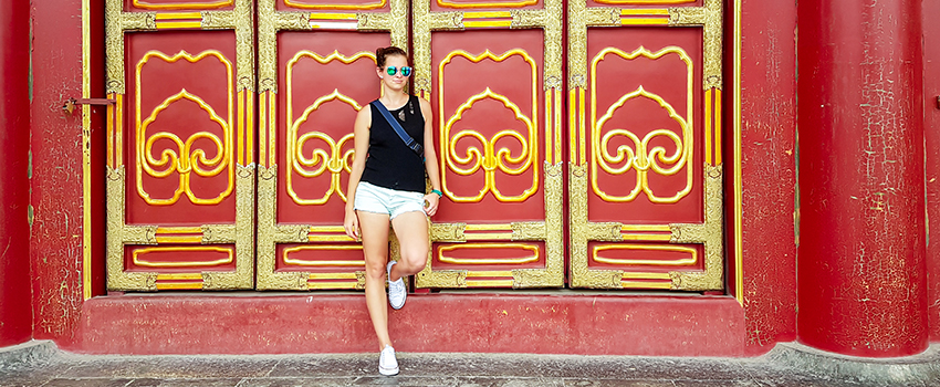 Student in front of Chinese building.