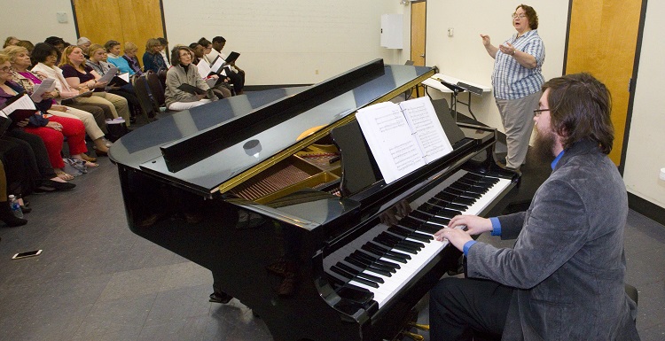 Christopher Powell, accompanist with the Mobile Opera, and Dr. Laura Moore, USA associate professor of music and director of Choral Activities, lead singers from three groups in a Tuesday rehearsal before this weekend's performance with the Mobile Symphony Orchestra.
