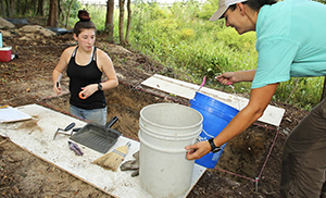 Students working outside on archeology dig.