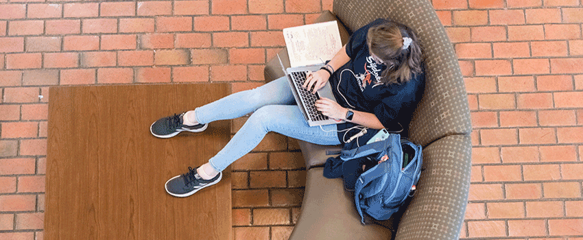 Looking down from above on a student studying with a laptop.