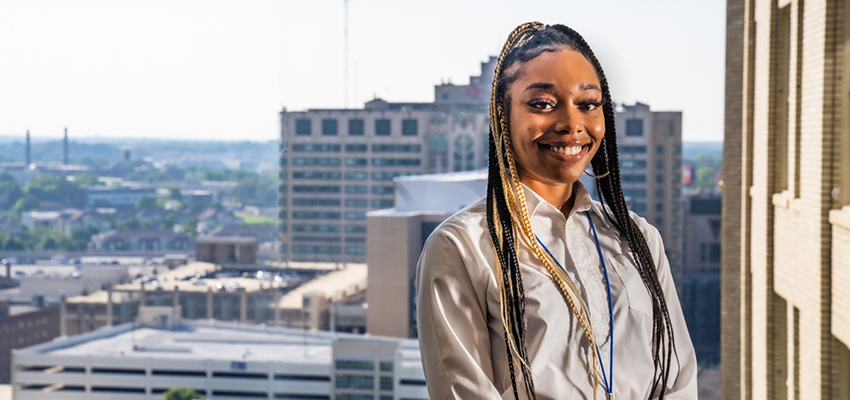 Mi’Asia Barclay standing in front of window with Atlanta in the background.