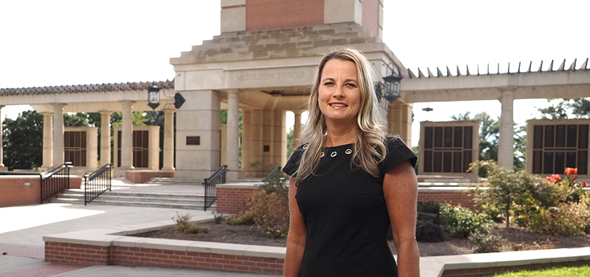 Dr. Andi Kent in front of the Moulton Tower on USA Campus.