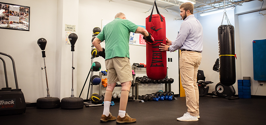 Dylan Thomas, right, an exercise science major, works with patients battling Parkinson’s disease at Saad Healthcare’s Rock Steady Boxing program in Mobile. 