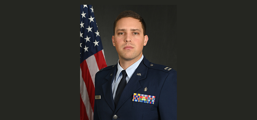 Captain Kane Jones in uniform in front of the American flag.