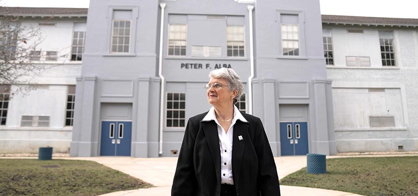 Martha Peek standing in front of Alba school.
