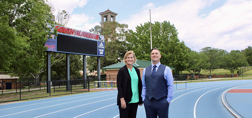 Dr. Craig Parkes and Shelley Holden standing on track on campus.
