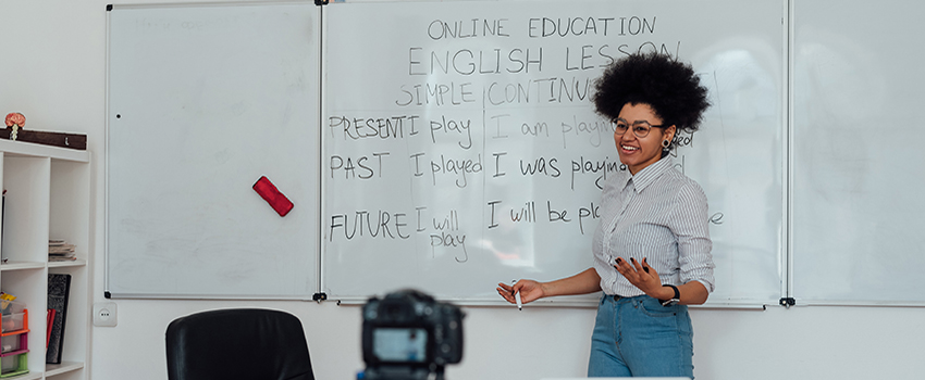 Female teaching English language at white board.
