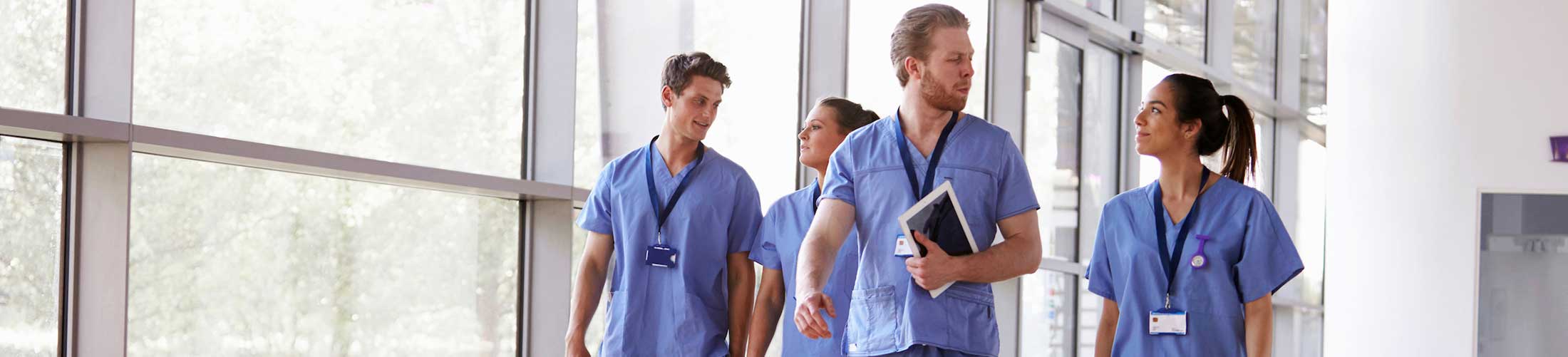 Medical workers walking through hospital talking to each other,