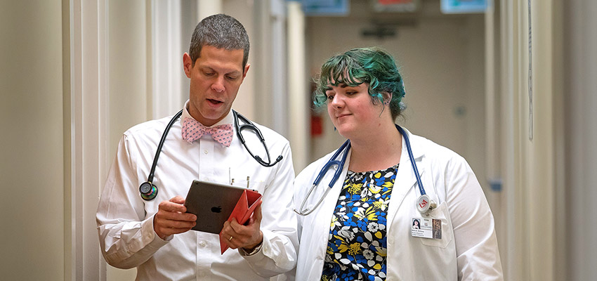 A medical student at the University of South Alabama College of Medicine talks with a physician.