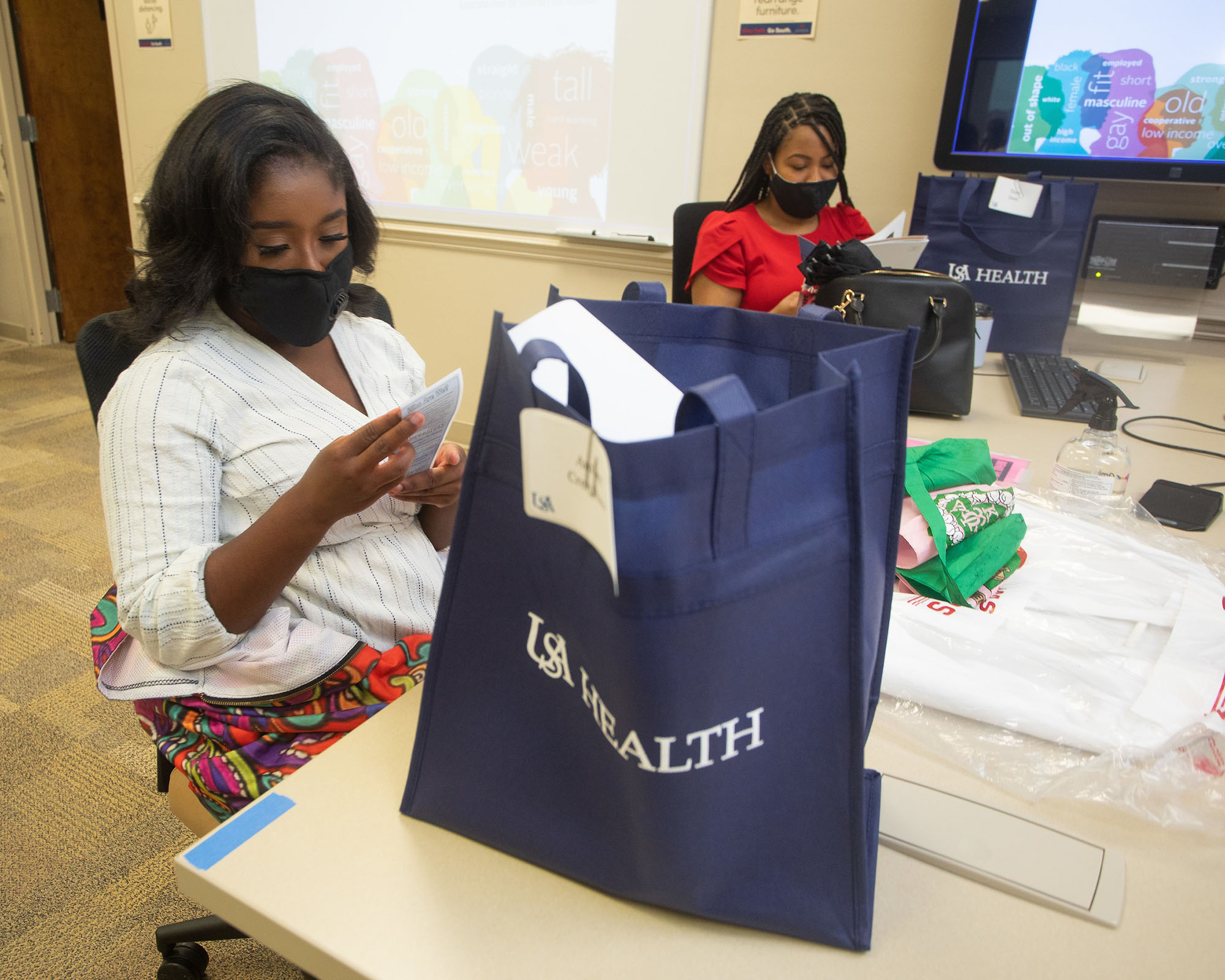 USA College of Medicine Class of 2024 medical students Amber Crenshaw (left) and Tiara Dean look through their USA Health gift bags during their M1 orientation.