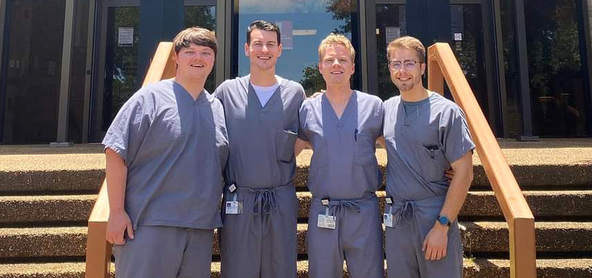 David Gahan of the Class of 2024, far right, poses with classmates outside the Medical Sciences Building.