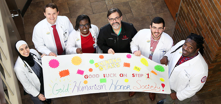 Medical students hold a sign encouraging those taking the Step 1 exam.