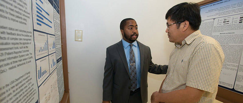 Malik McMullin explains his research to Dr. Steve Lim