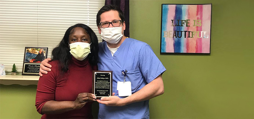 John Soltys, M.D., poses with GME staffer Tomeika Hawkins after receiving an award for serving as chair of the 2021-2022 USA House Staff Council. Soltys is headed to Oxford University for a fellowship in autoimmune neurology.