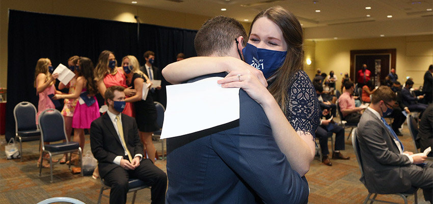 A couple who attended the University of South Alabama College of Medicine hug after revealing their residency match.
