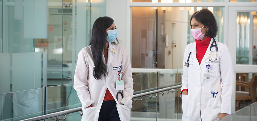 Internal medicine resident Sana Ozair, M.D., talks with Dr. Pranitha Proddutuvar, medical oncologist and assistant professor of interdisciplinary clinical oncology.  data-lightbox='featured'