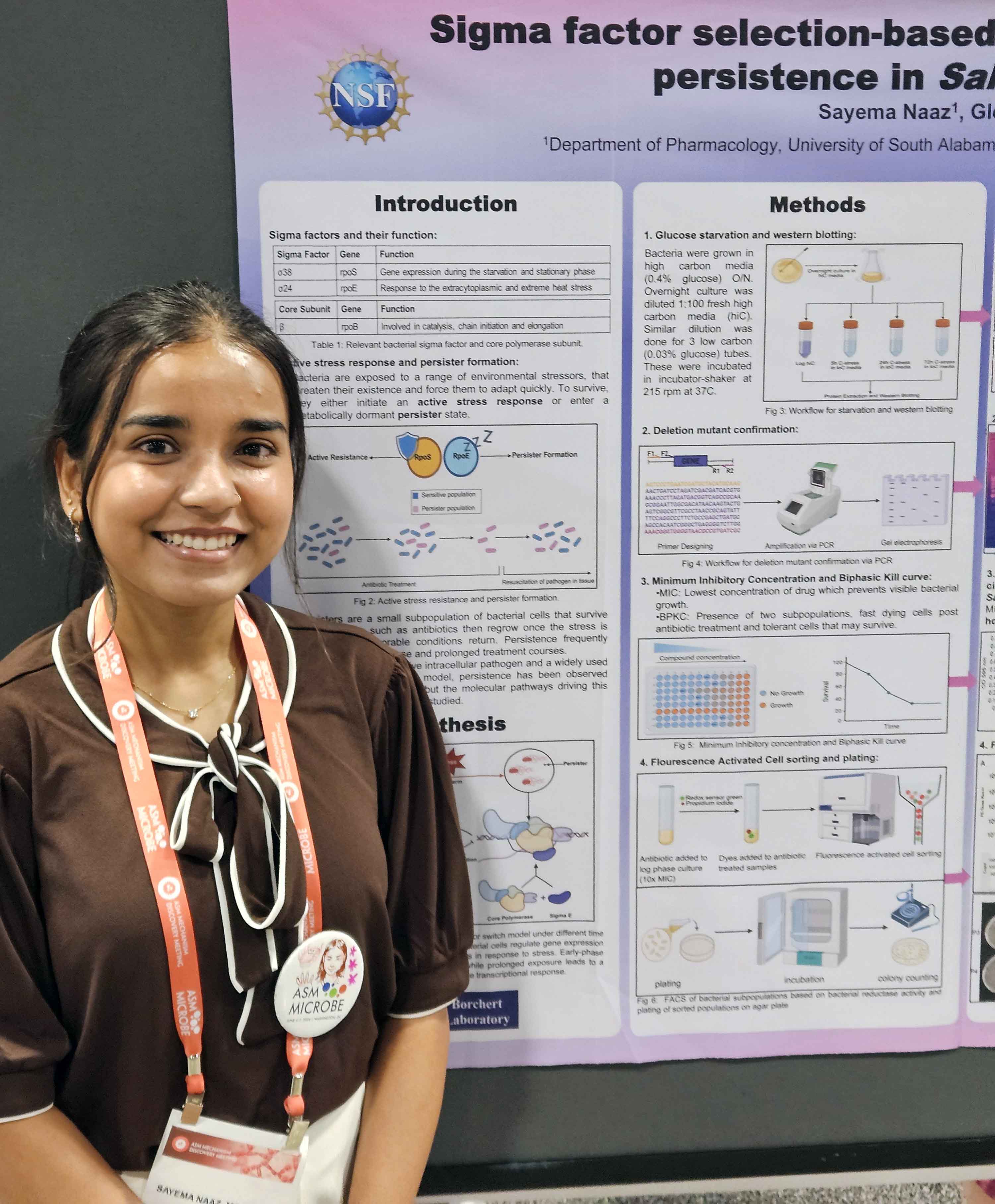 student in front of research poster