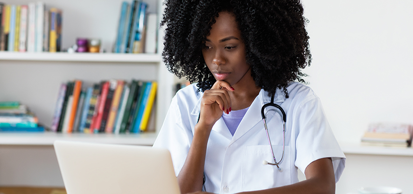 Nurse looking at laptop to apply for BSN in nursing.