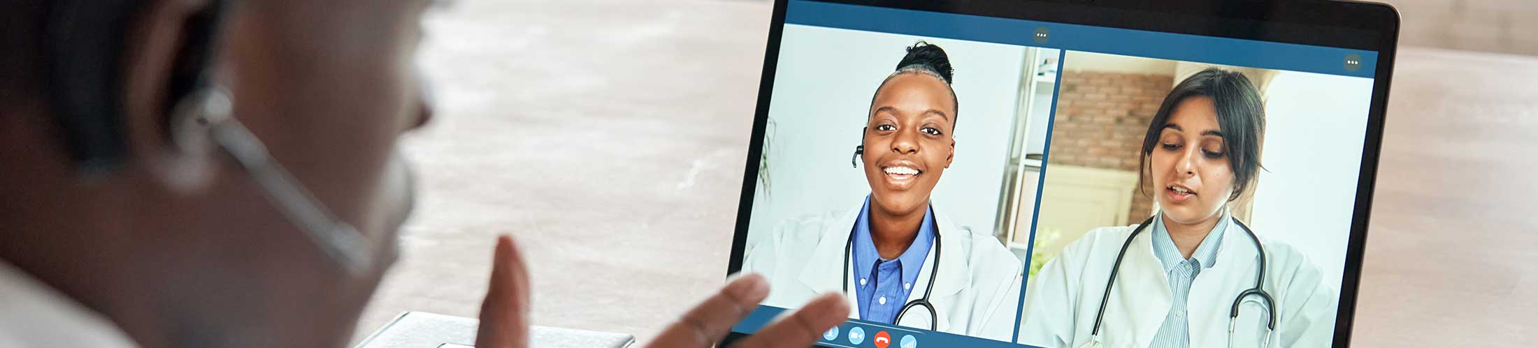 Man looking at computer screen with zoom meeting.