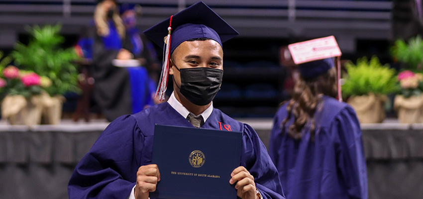 College of Nursing graduate wearing cap and gown.