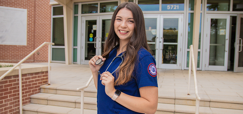 Katrina Horvath standing outside of the College of Nursing building.