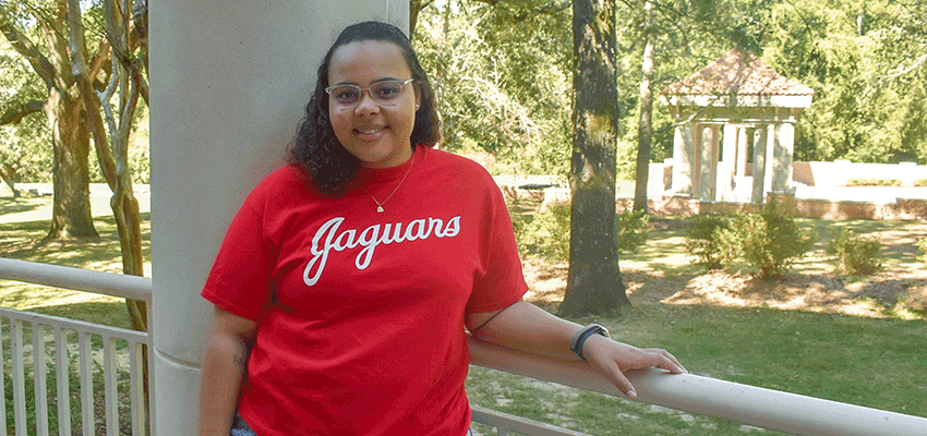 Nya Little with Jaguars shirt on standing outside on campus.
