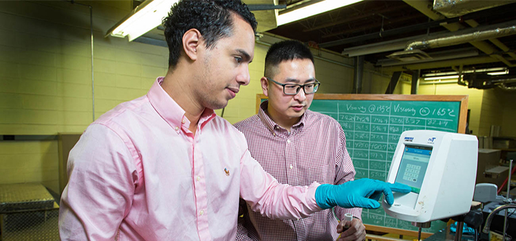 Omar Tahri and Assistant Professor Dr. Shenghua Wu working in the asphalt lab