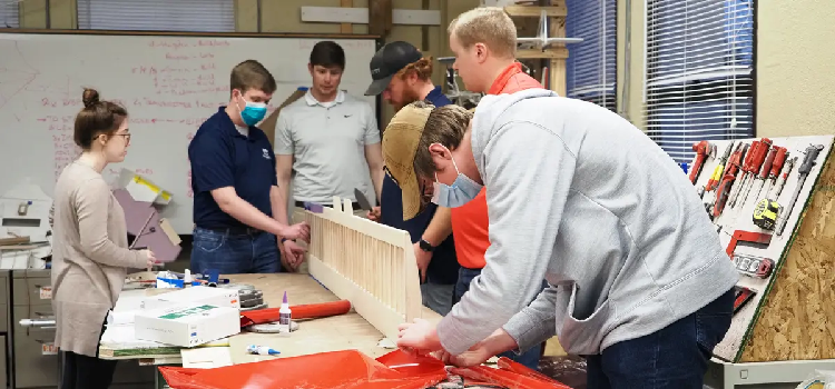 University of South Alabama mechanical engineering seniors, from left, Madison Bomeke, Hayden Jenkins, Bryson Hatcher, Will Sergeant, Gavin Brown and Evan Moulds work on a 82-inch-long wing that will provide stability for their remote-control cargo plane in the Design, Build, Fly competition. data-lightbox='featured'