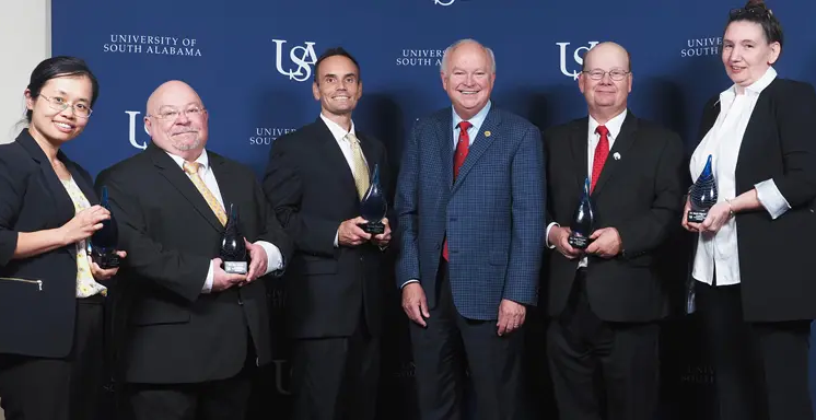 The University of South Alabama recognized five of its faculty members for excellence in research at the 2nd annual USA Technology and Research Showcase Oct. 24. From left, Dr. Na Gong, professor of electrical and computer engineering; Dr. James Davis, professor of chemistry; Dr. Jordan Shropshire, professor of information systems and technology; USA President Jo Bonner; Dr. Sean Powers, professor of marine and environmental sciences and senior marine scientists at the Dauphin Island Sea Lab; Dr. Marie Migaud, professor of pharmacology and oncology.