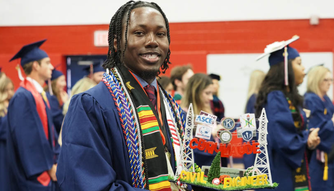 Lawrence Stoudemire showing his graduation cap he designed to reflect engineering and mortar board.