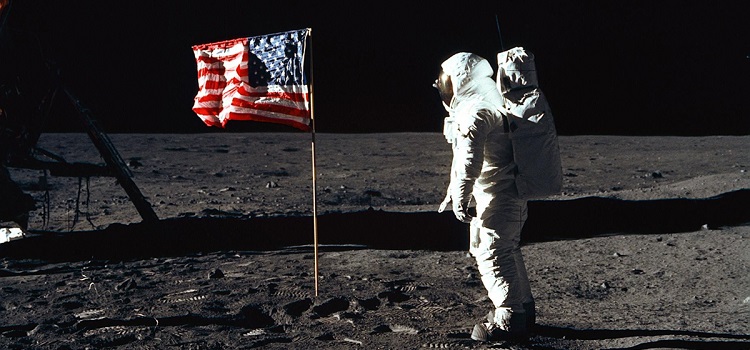 Astronaut Edwin "Buzz" E. Aldrin Jr., lunar module pilot of the first lunar landing mission, poses for a photograph beside the deployed United States flag. NASA photo.