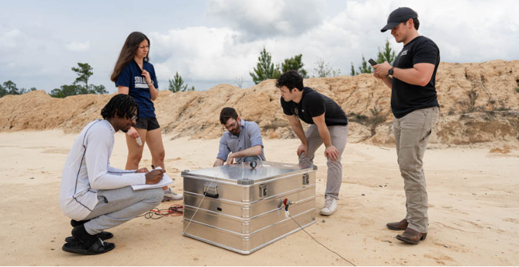 University of South Alabama students, from left, Devon Edinburgh, Paige Palazzo, Matthew Crump, Reed Turner and Luke Andress run though a series of tests on their senior research project at a firing range north of Mobile.