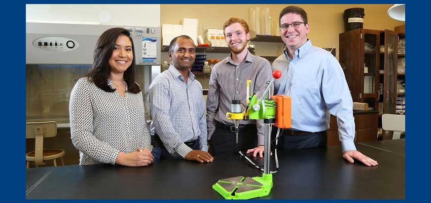 Dr. Dhananjay Tambe, second from left, an assistant professor in mechanical engineering and pharmacology, worked with engineering students, from left, Cassandra Chapman, Brandon Stokley and Quentin Morris to develop the "Tighten It" smart drill prototype. Chapman and Stokely graduated Saturday.