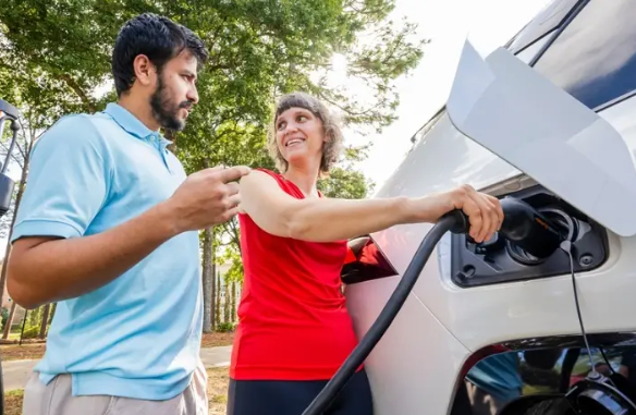 Dr. Daniela Touma next to electric car.