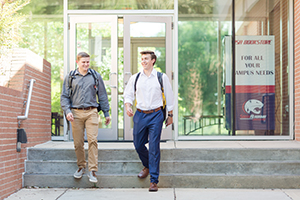 Two students walking out of MCOB
