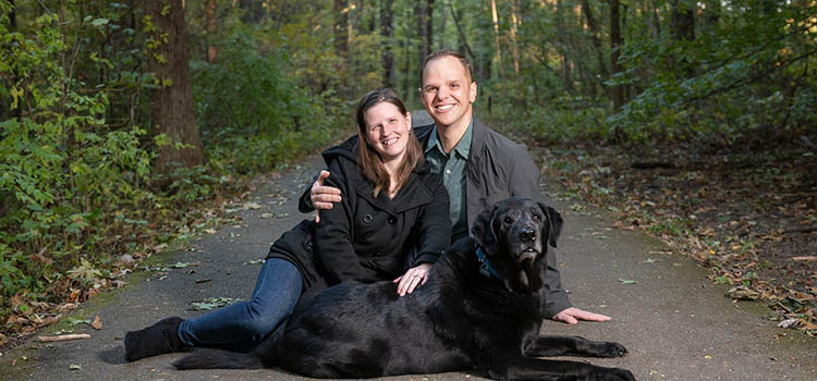 MCOB alumni, Jennifer Woods Crosby, with her husband, Patrick, and support dog, Beacon. 