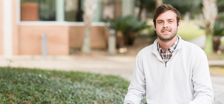 Alexander Rodman sitting outside on campus.